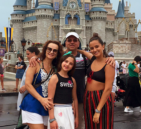 Foto de homem junto da esposa e filhas na Disney